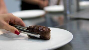 Beef steak Process of cutting the steak with a large kitchen knife on a cutting board. The juicy beef meat is cut into pieces. Close-up of the chef's hand, slow motion. 4k footage video
