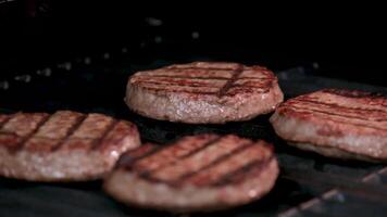 Raw burger cutlets, top view on beautiful background with a black stand, rosemary and peppercorns video