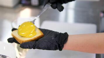Spread mustard on bread Spreading sauce from mayo, ketchup, mustard on top of a toasted burger bun in 4K. Concept of spreading burger sauce on a grilled bread bun. video