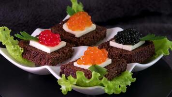 Sandwiches with caviar food background. several sandwiches with red caviar rotate on a plate. close-up. video