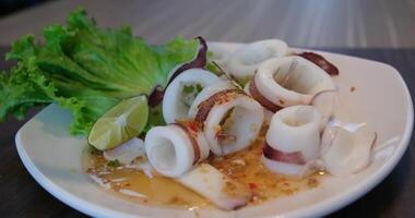 Frozen squid rings on a simple background. Squid rings video