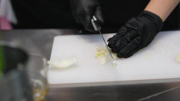 Cutting onions Close-up Chef chopping an onion with fine pressure on a cutting surface in professional kitchen video
