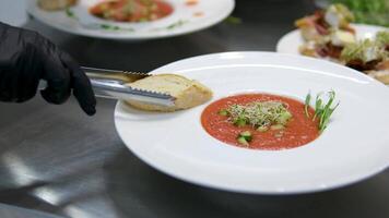 creamy tomato soup with bread croutons seen from above on black table with copy space video