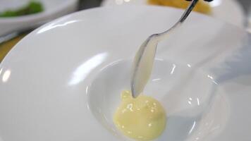 Semolina porridge plate. Milk semolina porridge with a slice of melted butter in a white deep plate on a stand from a shallow plate on a white background video
