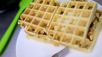 Square waffles Gold Belgian or Viennese waffles close-up. Waffle texture or background. Homemade baking for breakfast. video