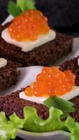 Sandwiches with caviar food background. several sandwiches with red caviar rotate on a plate. close-up. video