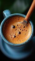 A steaming cup of coffee with a silver spoon resting inside it photo