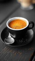 A steaming cup of freshly brewed coffee on a saucer with a spoon photo