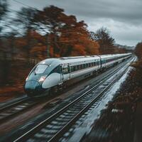 A train is steadily traveling down the tracks on a cloudy day photo
