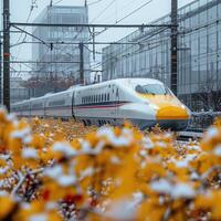 A bright yellow and white train is traveling through a snowy field photo
