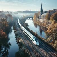 A train is traveling along the tracks that run beside a flowing river photo