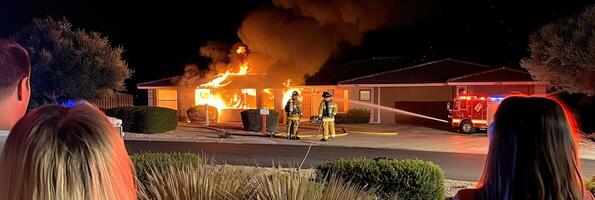 fire in the house. the burning house is being extinguished by firefighters with hoses photo