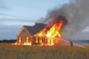 fire in the house. the burning house is being extinguished by firefighters with hoses photo