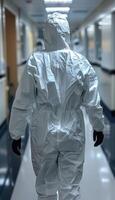 A person dressed in a protective suit is walking down a long hallway photo
