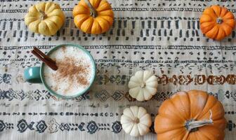 A pumpkin spice latte with a cinnamon stick photo