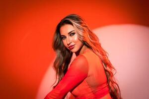 Close-up of a model on an orange background in a blouse with an expressive and penetrating gaze. Banner, poster with place for text photo