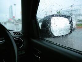 View of the side mirror of a car while it is raining. photo