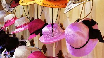 Colorful hats displayed in a street shop photo