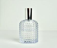 Unisex textured glass perfume bottle container with lid on isolated on horizontal white background. photo