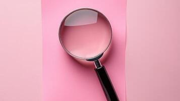 Magnifying glass resting on pink background with copy space photo