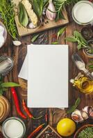 Blank cookbook on a wooden table with cooking ingredients and utensils. photo
