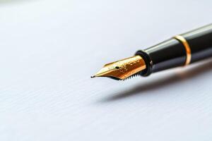Elegant golden fountain pen lying on a white sheet of paper photo