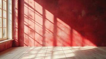 Sunlight casting geometric shadows on a red wall in an empty room photo
