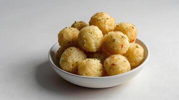 Crispy fried potato balls in white bowl on white background. photo