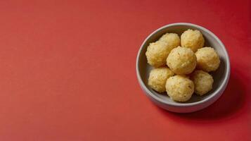 Cheese balls in a bowl on a red background with copy space photo