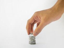 The hand is stacking Indonesian rupiah coins, isolated with a white background. photo