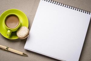 blank spiral notebook with dotted paper, flat lay with coffee on textured art paper photo