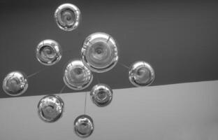 Modern chandelier background, round lamps over ceiling pattern. Black and white photo background