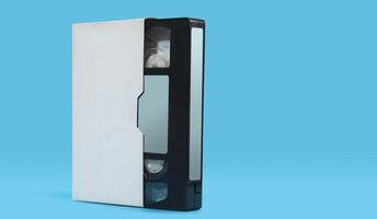 old black plastic VHS cassette with white case on a blue surface against blue background photo
