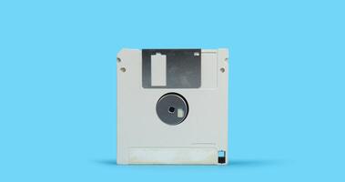 old white plastic square computer floppy disk on a blue surface against blue background photo