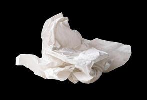 Side view of white screwed or crumpled tissue paper ball after use isolated on black background with clipping path photo