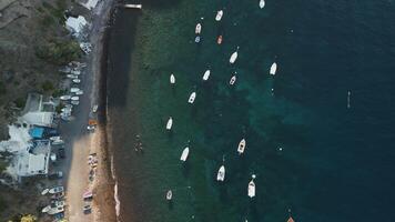 Flying above some boats at a beach in Santorini Island video