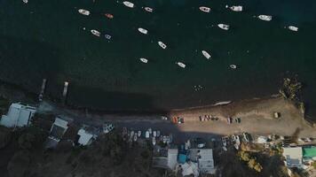 Flying above some boats at a beach in Santorini Island video