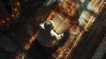 An overhead angle shows a Muslim man reading the Quran in a peaceful setting with a dim and serene nighttime background. photo