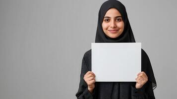 Smiling Woman in Hijab Holding a Blank Sign photo