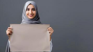 Woman in Hijab Smiling and Holding a Blank Paper photo