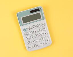 flat lay of blue calculator on yellow background with copy space. photo