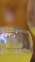 Pour orange juice Squeezing juice from half a tangerine to the glass by hand pressure, view on a background of other whole tangerines on a table video