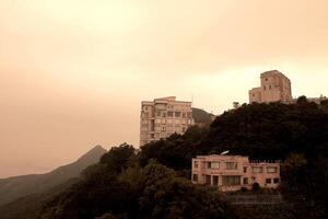 A View of couple isolated houses on the hill which have been shot from Victoria Peak in Hong Kong, China at sunset photo