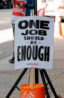 Vancouver, Canada - September 27,2019 View of sign One Job should be enough on Hastings Street in front of Pinnacle Hotel. Striking hotel workers block street in downtown Vancouver photo