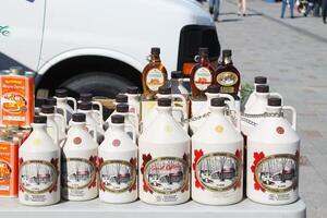 Kingston, Canada - August 13,2017 Close up shot of many bottles of famous maple syrup brand in Ontario. Sunday market. photo
