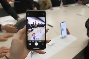 Vancouver, Canada - September 20,2019 Apple officially started selling the iPhone 11 and iPhone 11 Pro. Woman is holding iPhone 11 Pro showing the amazing ultra wide angle camera at local Apple Store photo