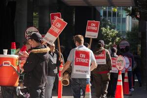 Vancouver, Canada - September 27,2019 Activists are walking on Hastings Street in front of Pinnacle Hotel. Striking hotel workers block sidewalk in downtown Vancouver photo