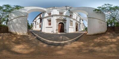 full hdri 360 panorama of portugese catholic church with arches in jungle among palm trees in Indian tropic village in equirectangular projection with zenith and nadir. VR AR content photo