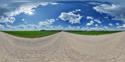 hdri 360 panorama of blue sky with awesome clouds on roadside of gravel road among fields in equirectangular full seamless spherical projection, for VR AR content or skydome replacement photo