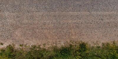 view from above on texture gravel road with median with lawn photo